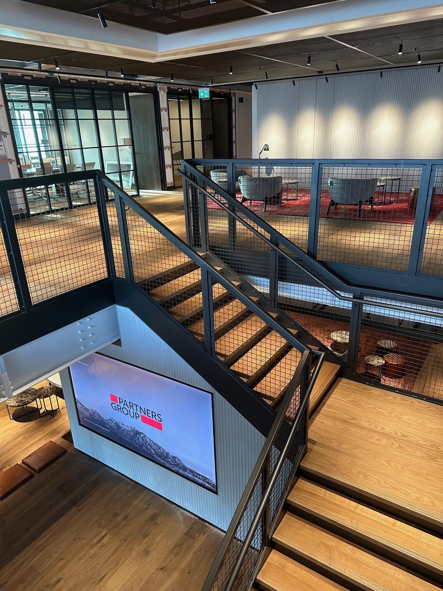 An aerial view of a staircase in a building with a large screen on the wall.