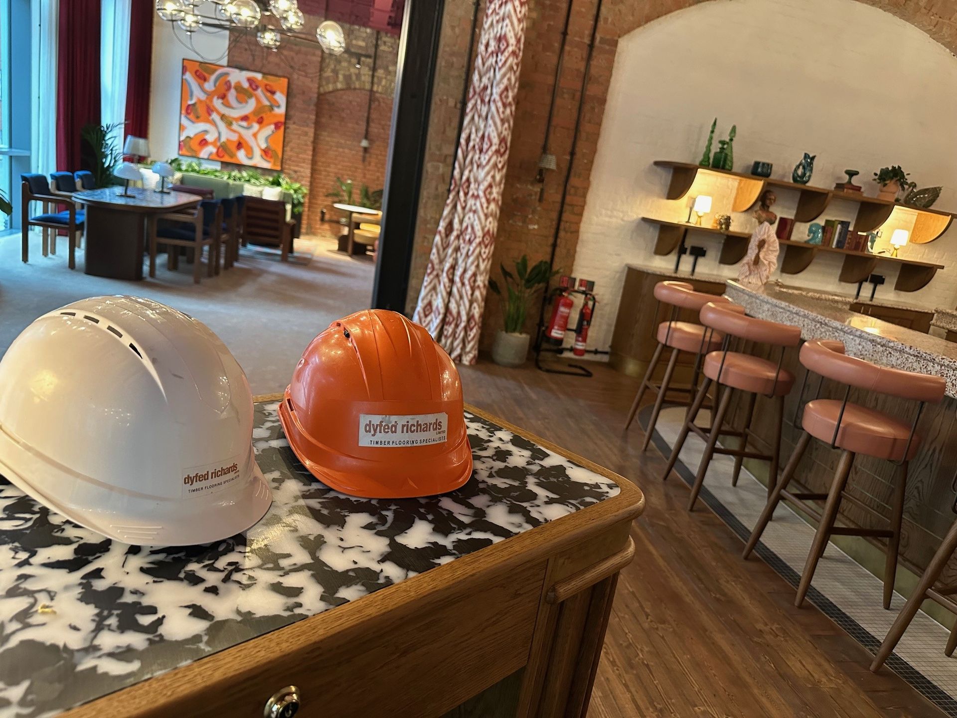 Two hard hats are sitting on a table in a room.