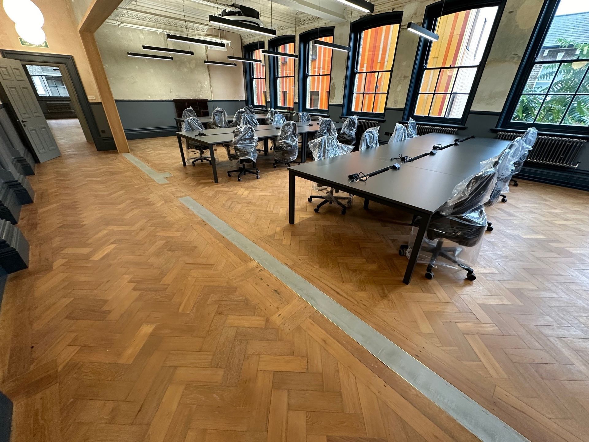 meeting tables in walworth town hall with large windows and a wooden parquet floor