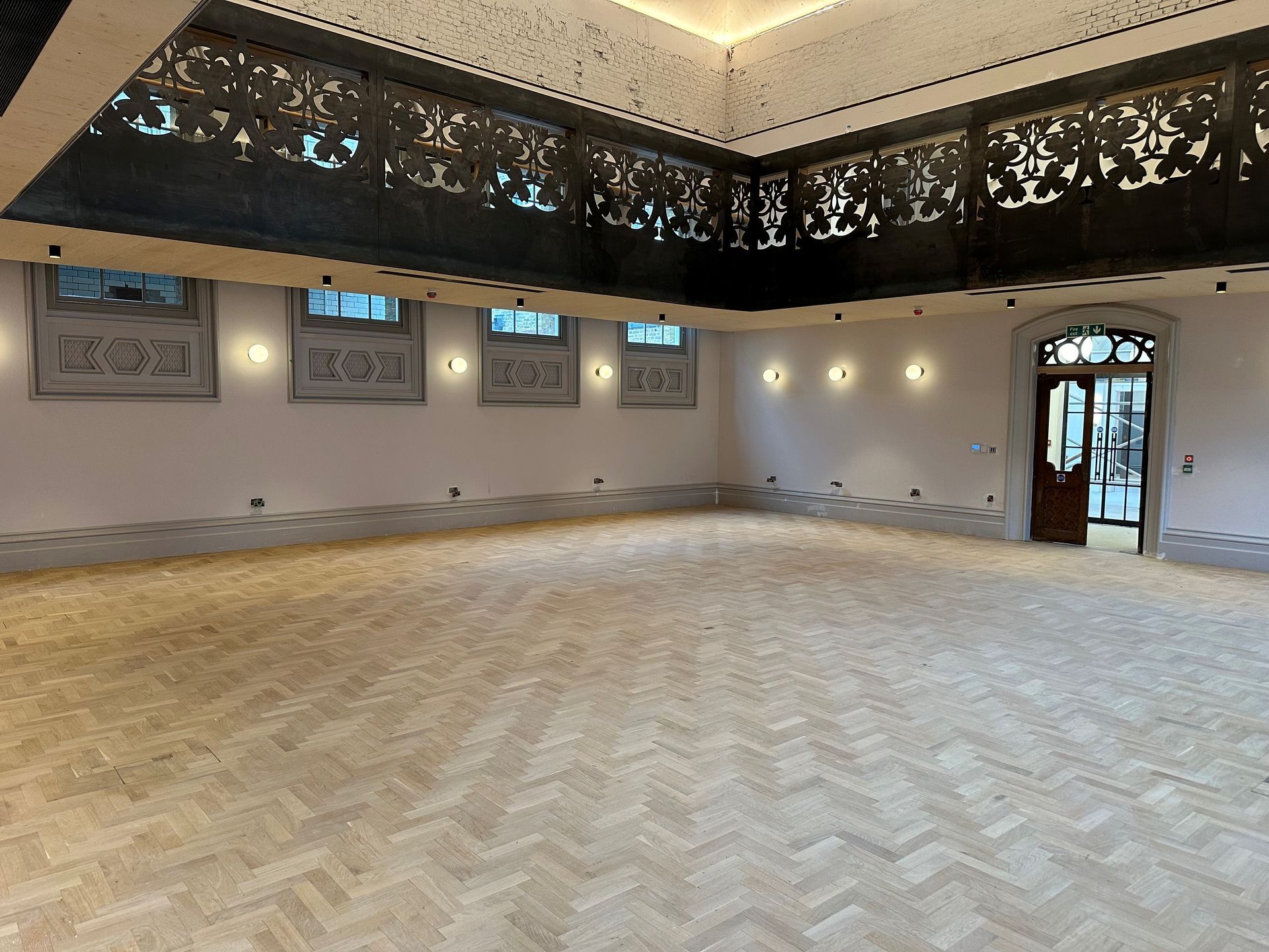 A large empty room with a wooden floor and a ceiling