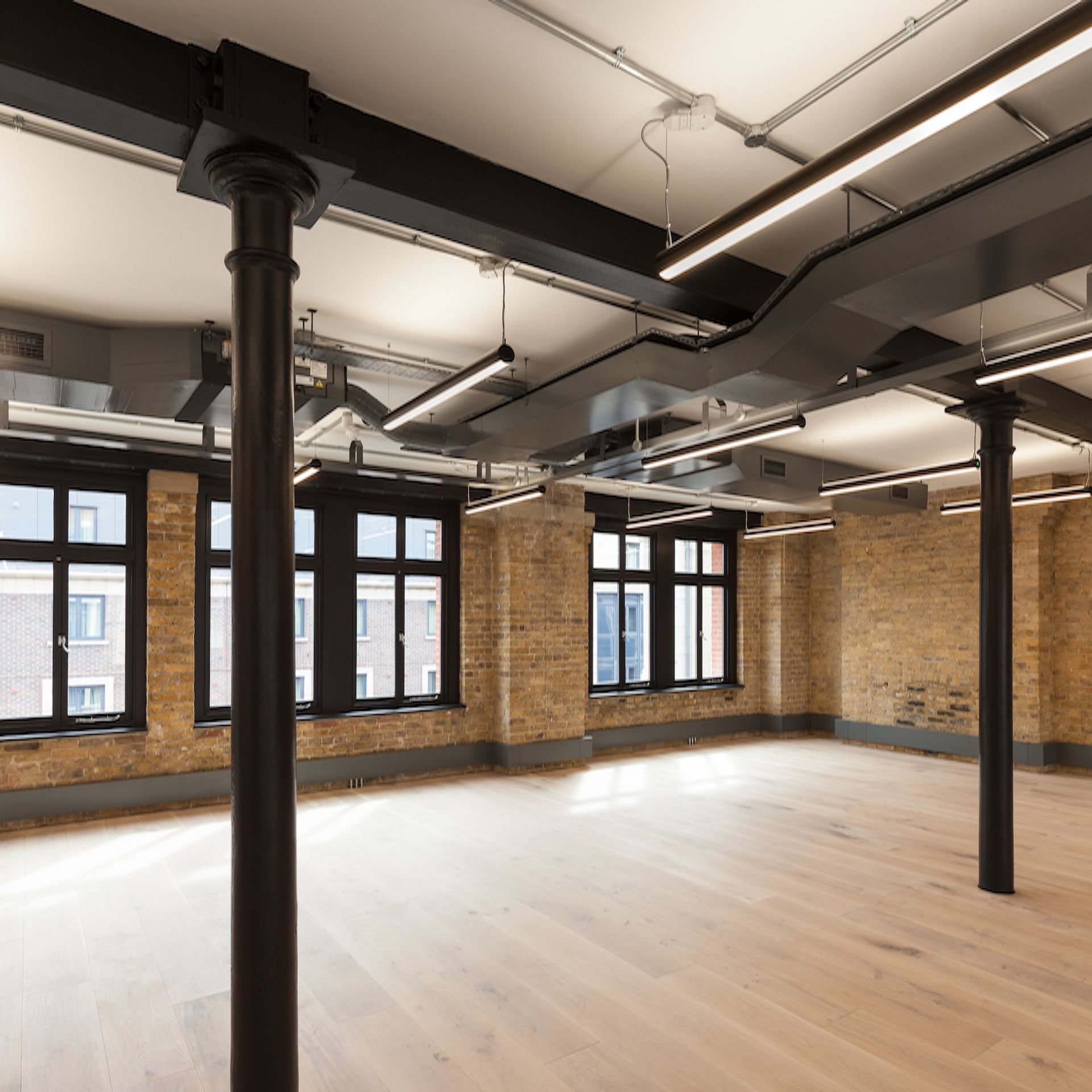 An empty room with brick walls and wooden flooring