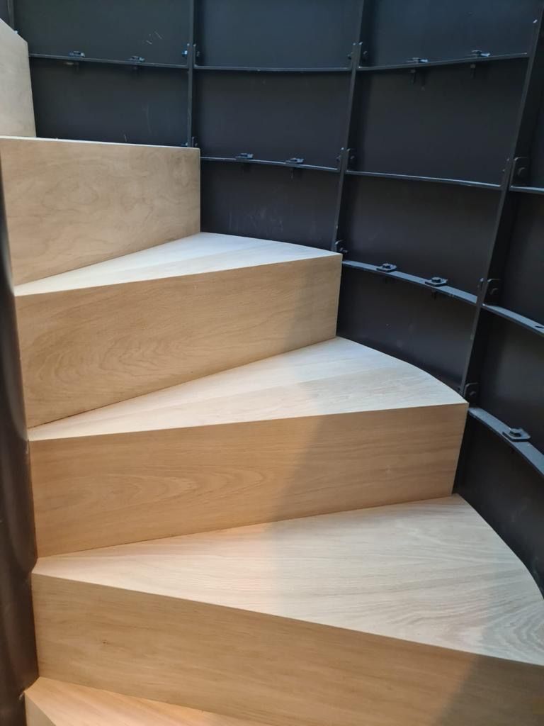 A close up of a wooden staircase with a metal railing.