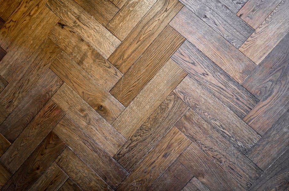 Herringbone pattern wooden floor, brown with variations in shade.