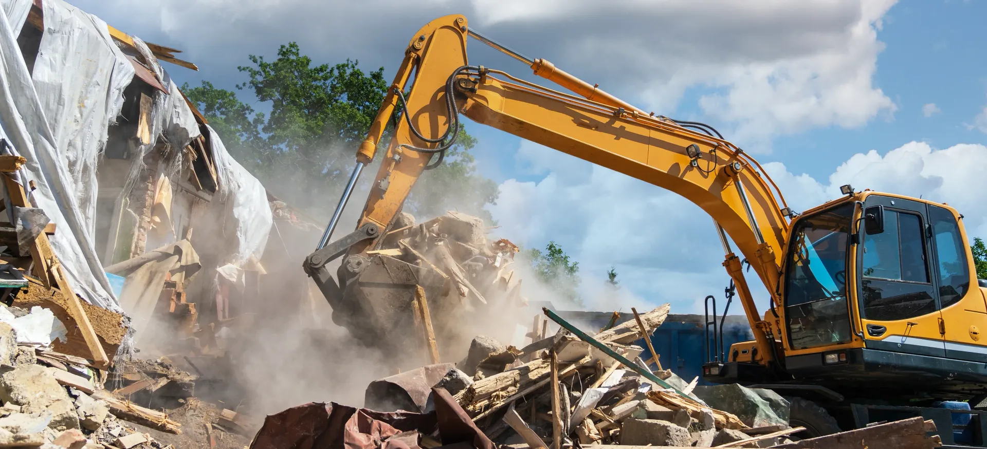 Yellow Excavator Demolishes Building, Raising Dust — Brucic Construction in Queanbeyan, NSW