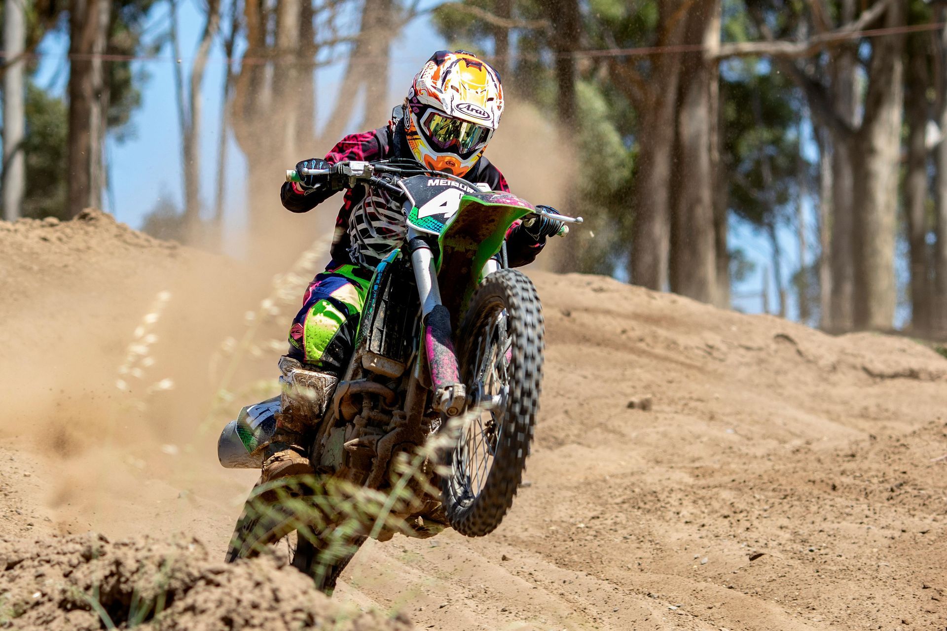 A person is riding a dirt bike on a dirt track.