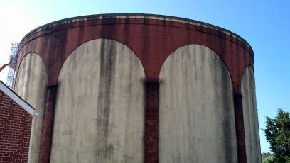 A large concrete water tank with arches on the side of it.