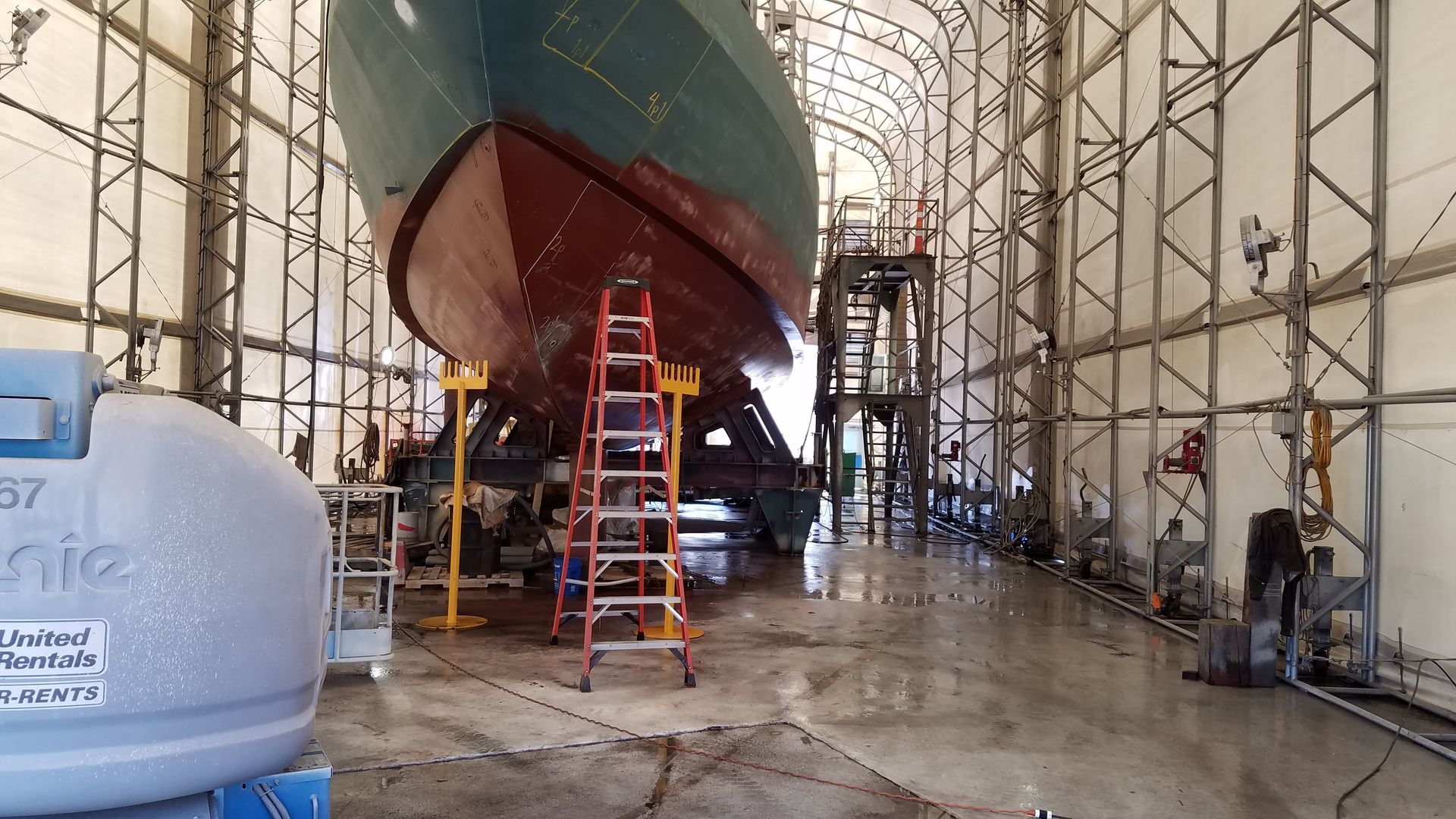 A large boat is being built in a large building
