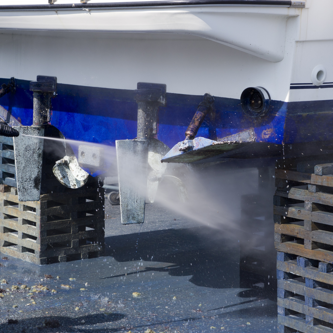 A boat is being cleaned with a high pressure washer