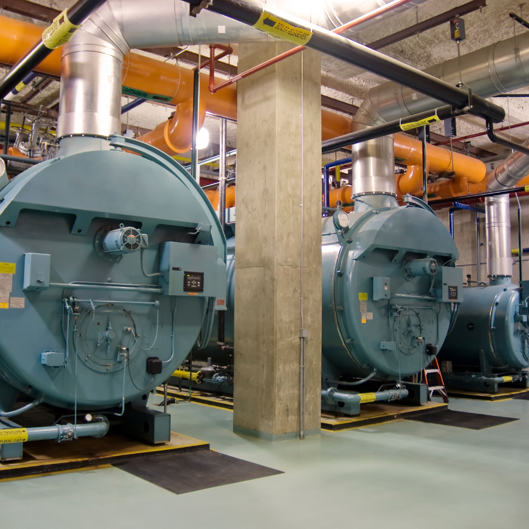A row of blue boilers are lined up in a room