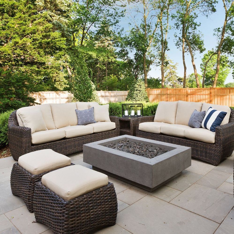 A patio with wicker furniture and a fire pit