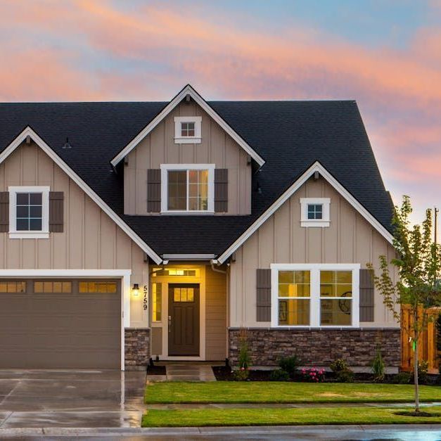 A large house with a black roof and a garage.