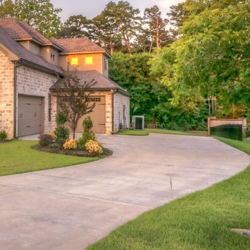 A brick house with a driveway leading to it