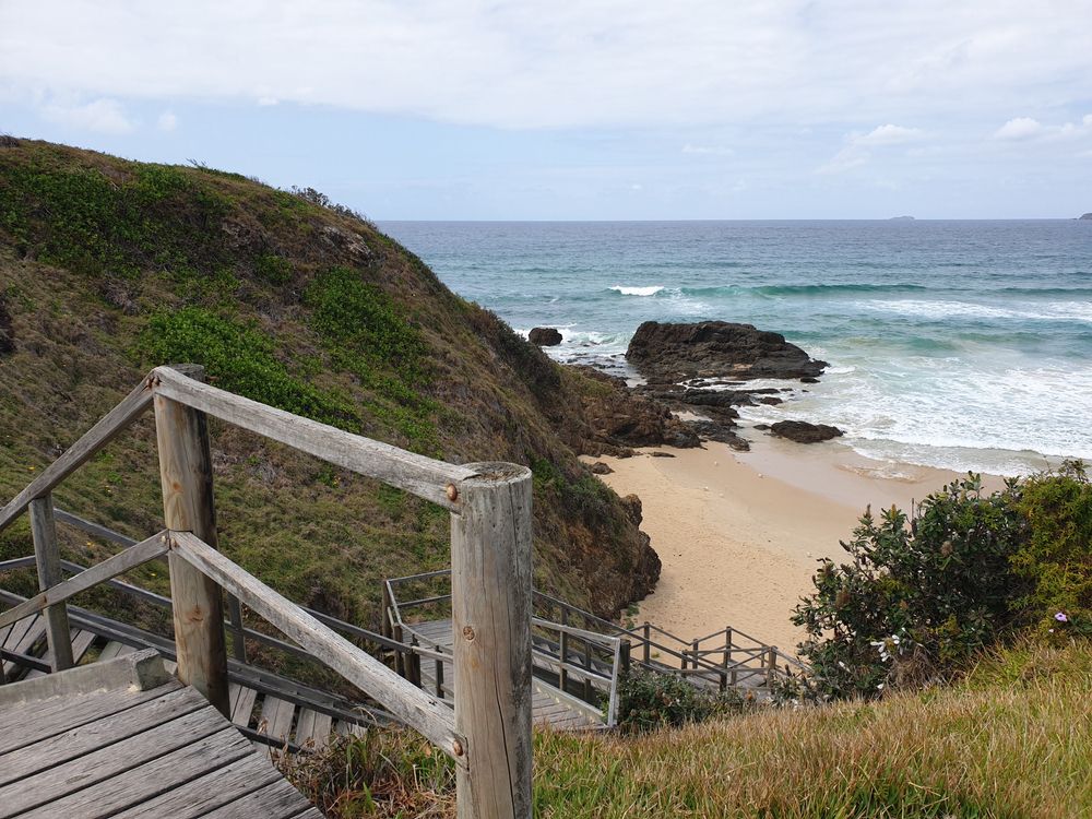 A Wooden Staircase Leading to a Beach With a View of the Ocean — Able Building And Pest Inspections In Woolgoolga, NSW