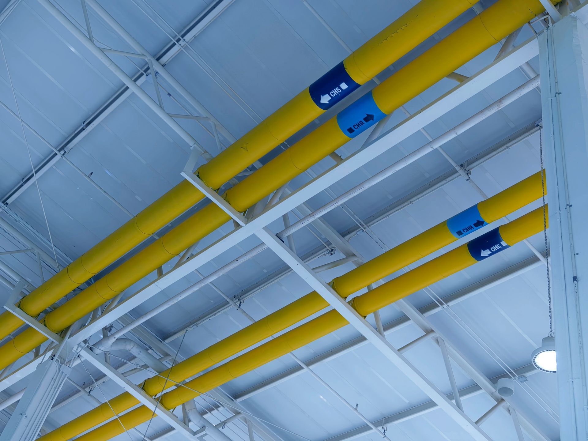 A bunch of yellow pipes are hanging from the ceiling
