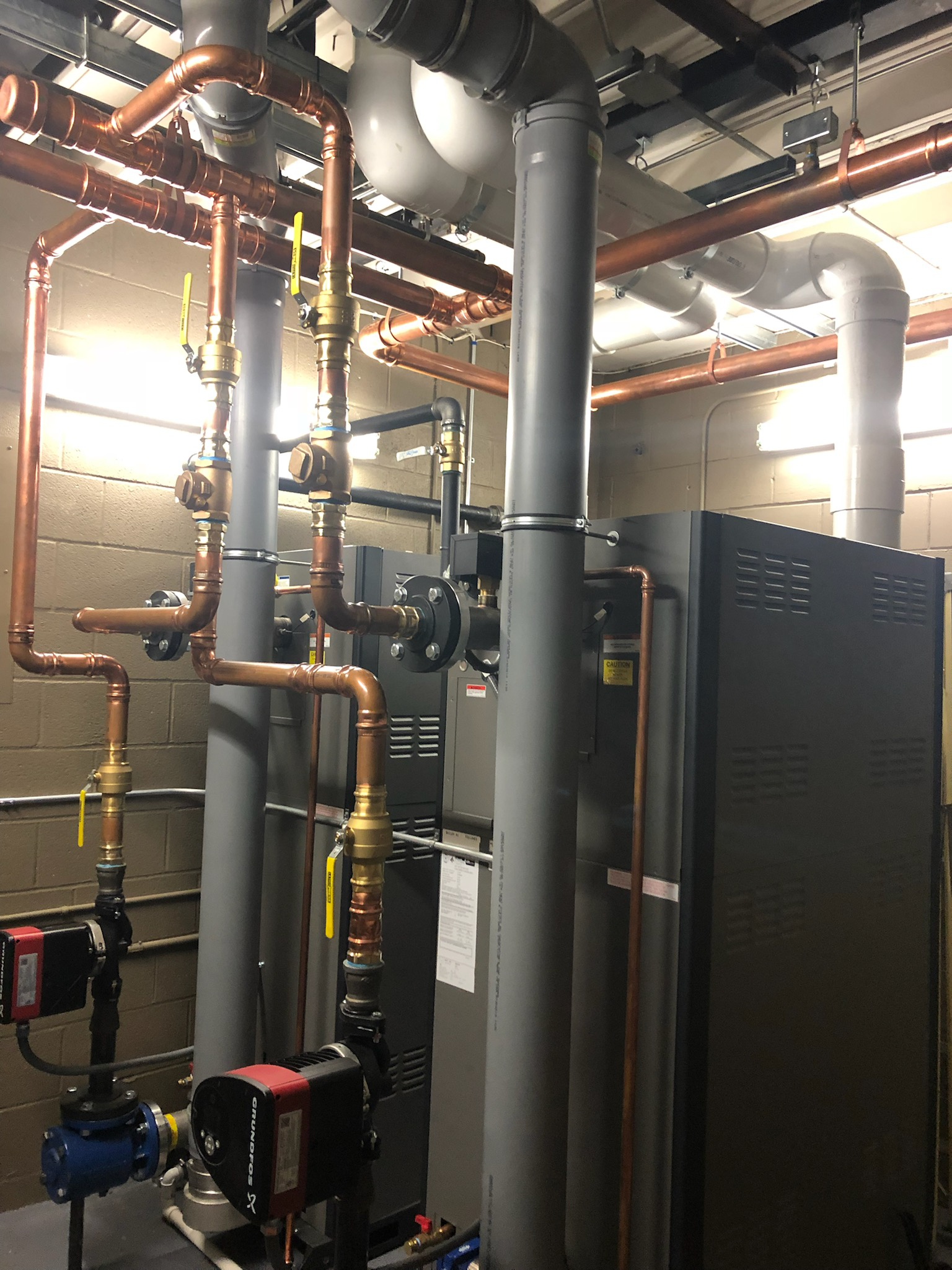 A room filled with lots of pipes and a boiler.