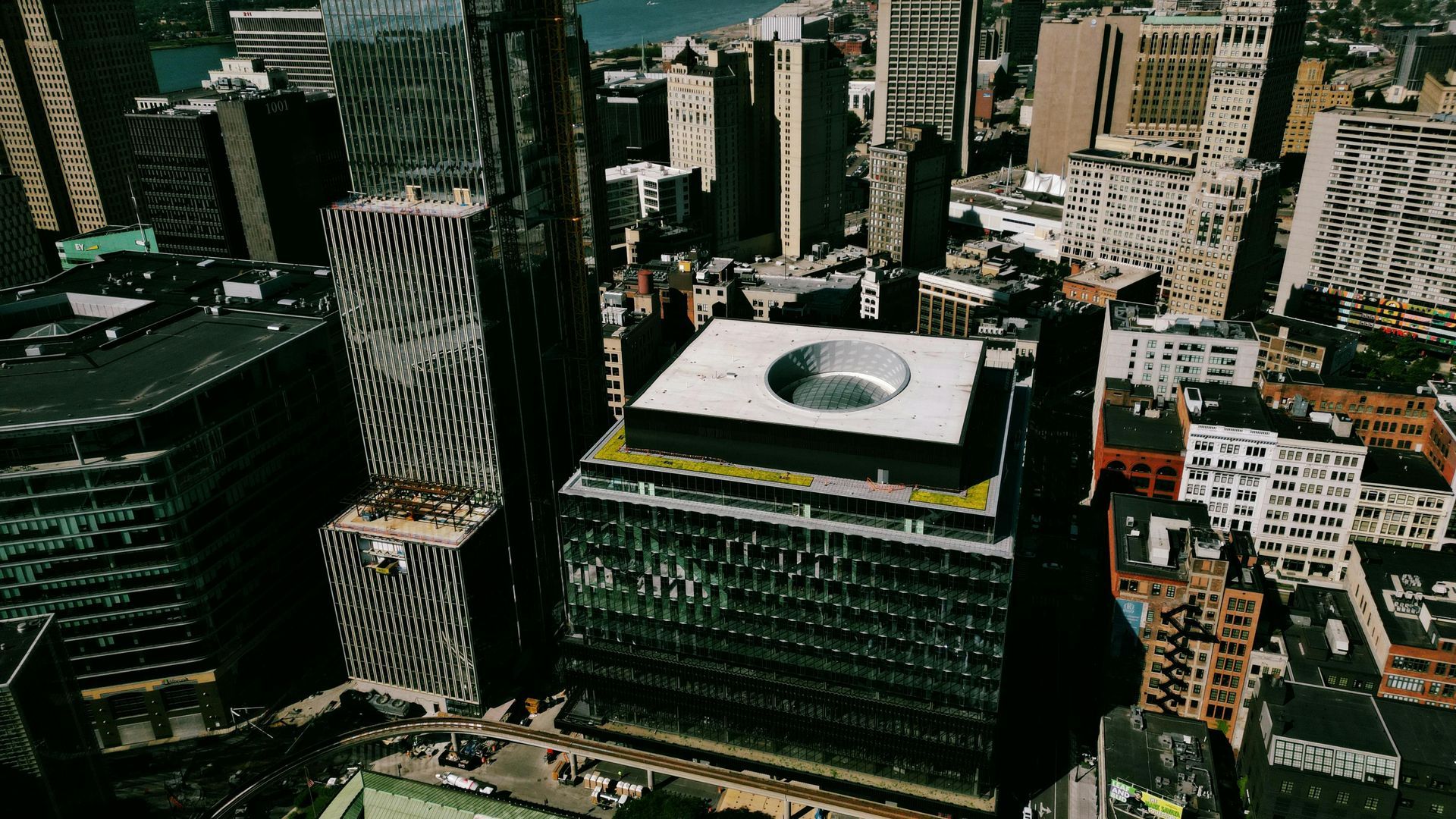 An aerial view of a city with a large building in the middle of the city.