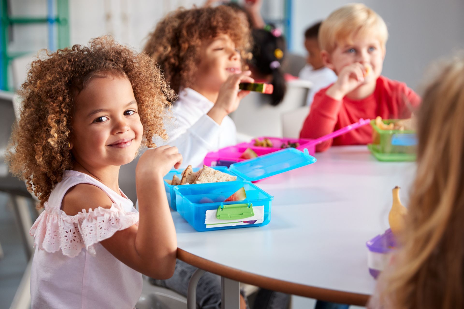 Group of children eating healthy food in day care centre