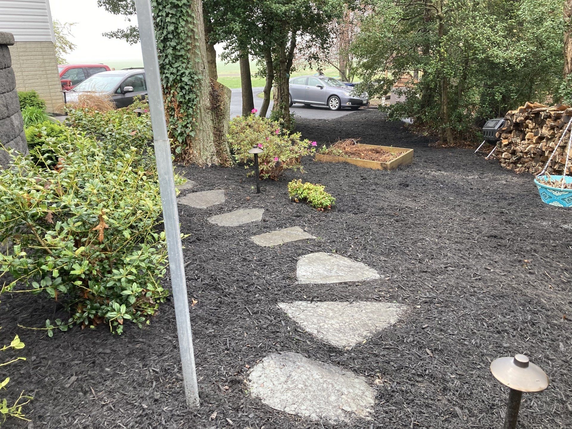 Stepping-stone path through a mulched garden with shrubs and trees