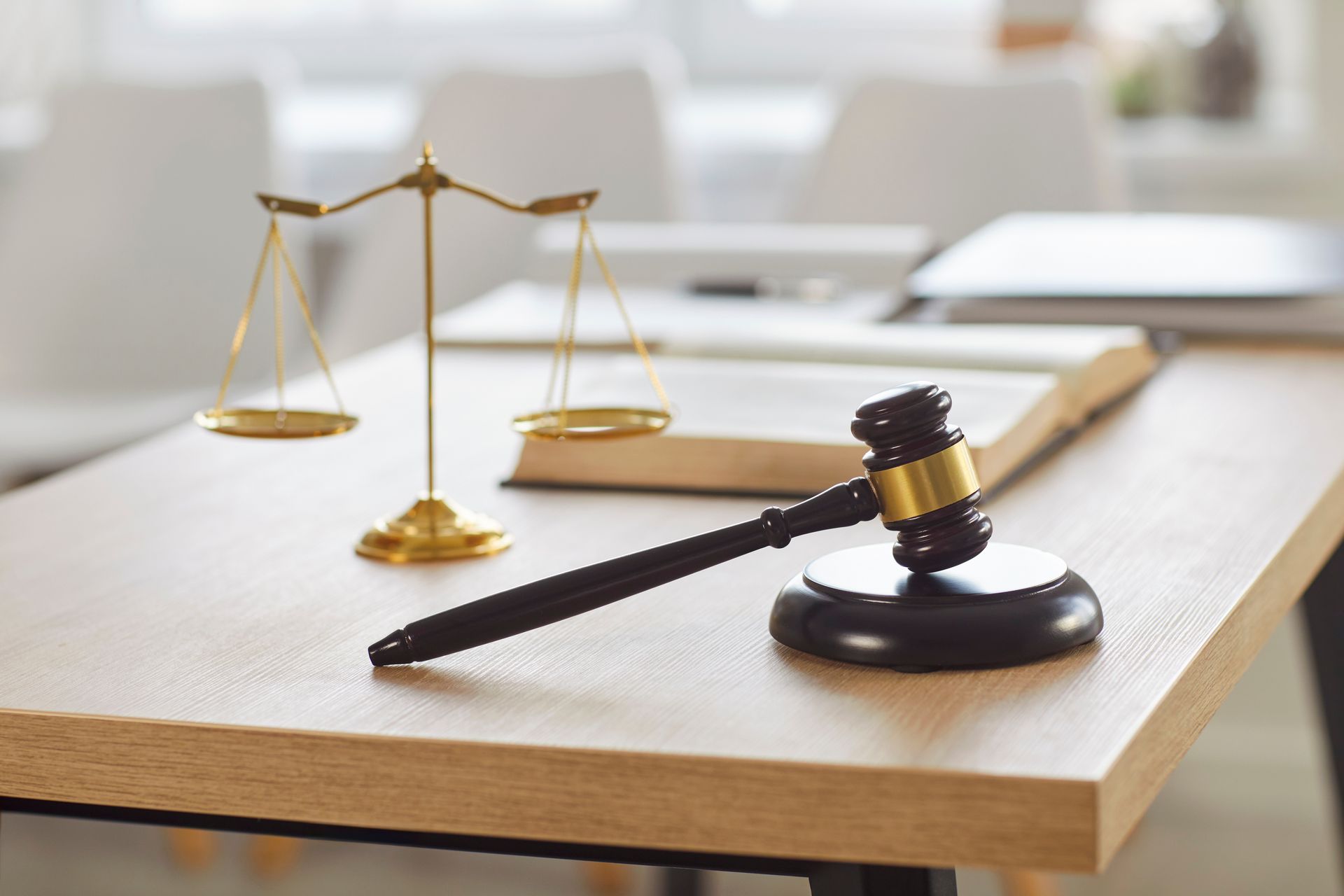 Wooden gavel and gold balance scales for a trusted criminal defense attorney. Wooden gavel and gold balance scales for a trusted criminal defense attorney.
