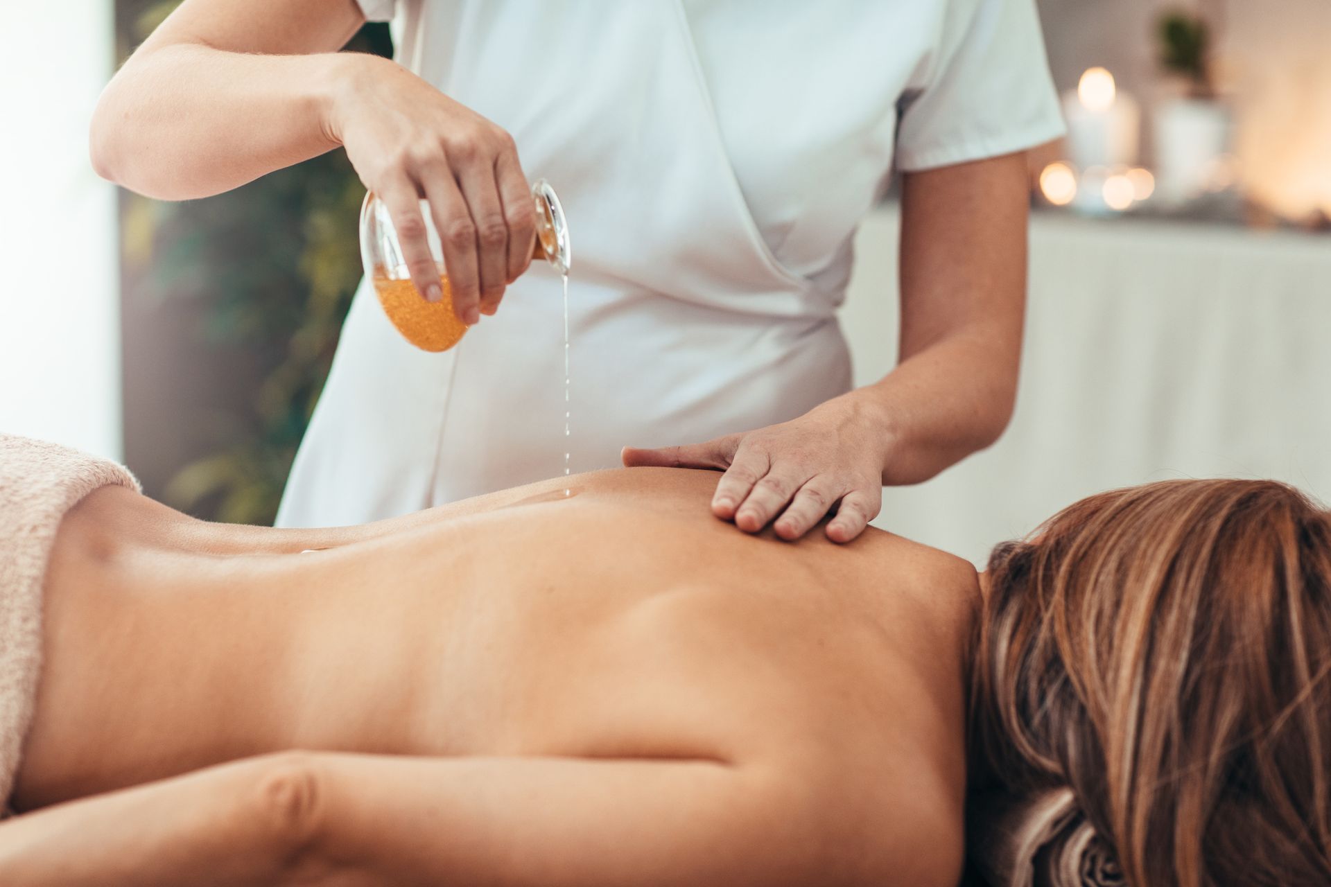 A woman is getting an oil massage at a spa.