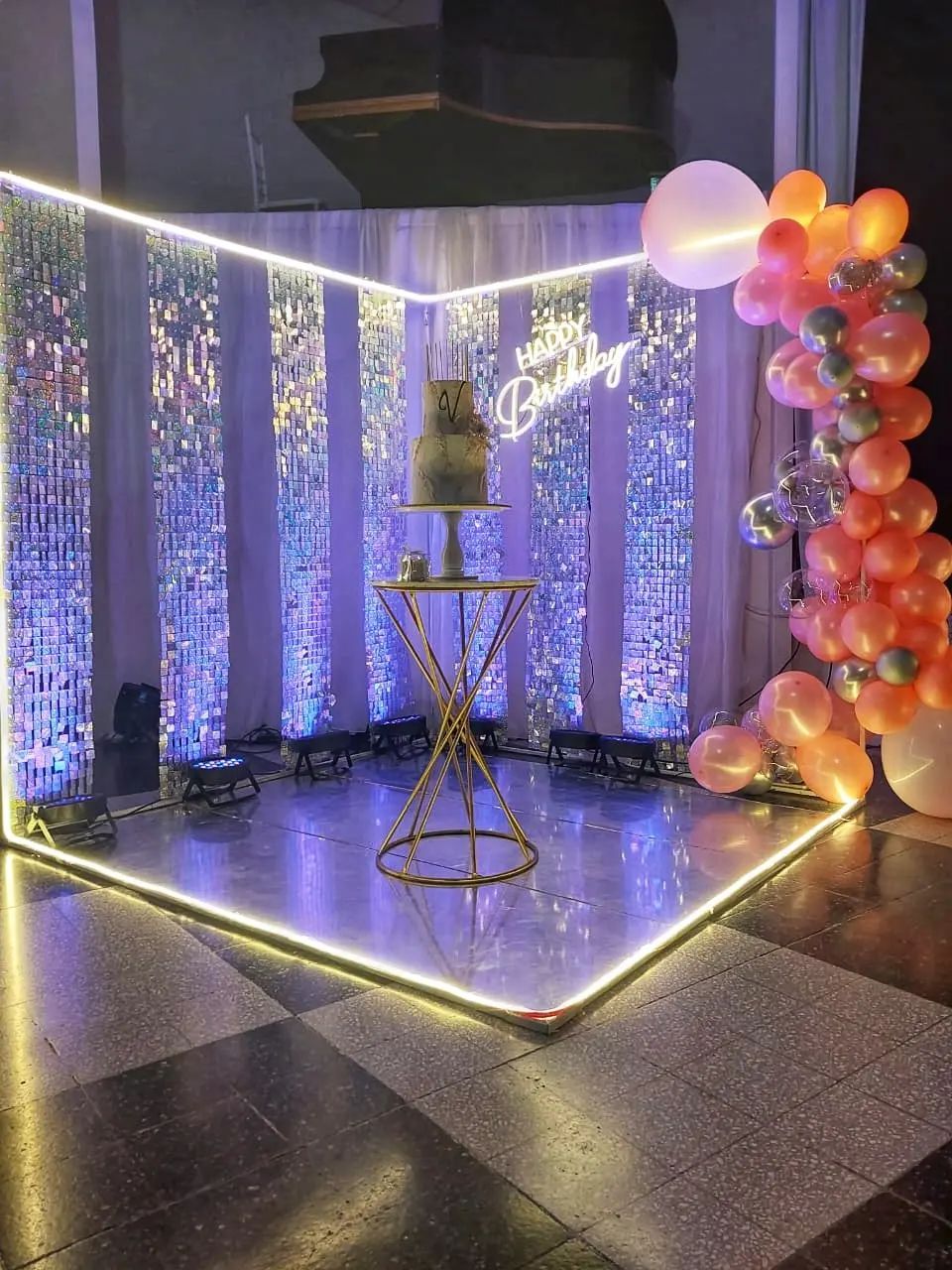 Una habitación decorada para una fiesta de cumpleaños con globos y un pastel en una mesa.