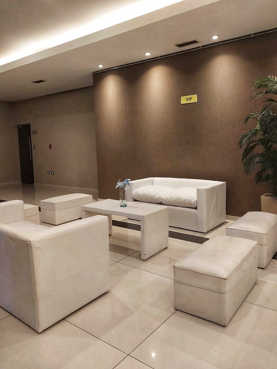 Una sala de estar con muebles blancos y una pared marrón.