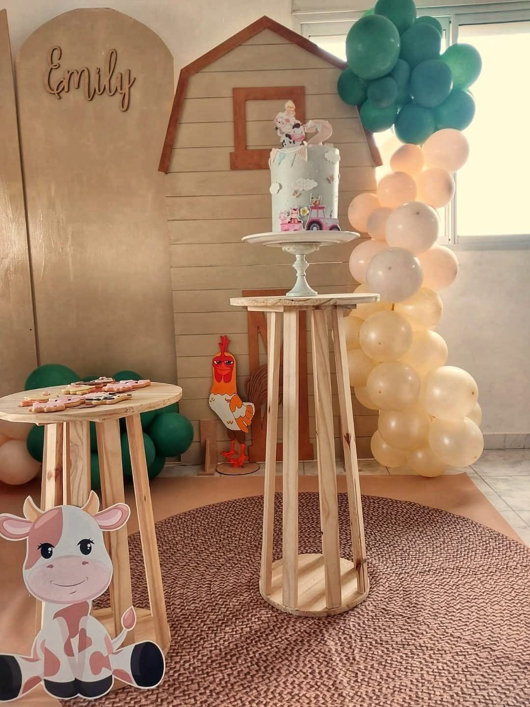 Una habitación decorada con globos, mesas, una vaca y un pastel.