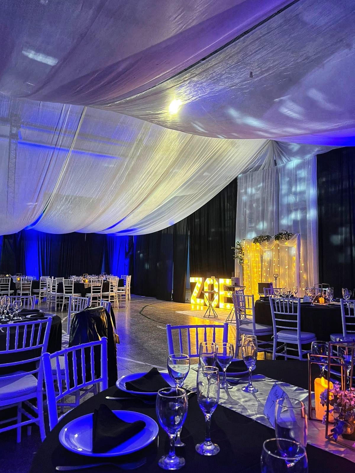Una gran sala con mesas y sillas preparadas para una recepción de boda.