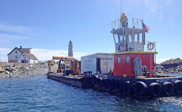 Offshore logistics at Boston Light — tugboat and barge delivering materials to Little Brewster Island for lighthouse restoration by Cenaxo