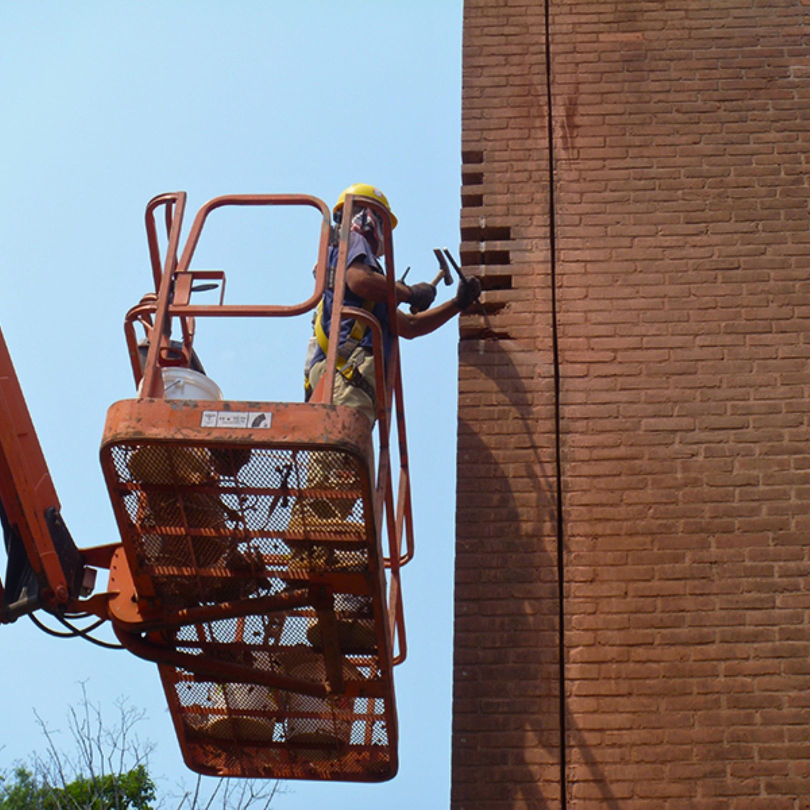 Cenaxo mason performing brick repointing on a historic building facade