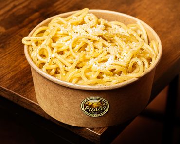Piatto di spaghetti con salsa cremosa e pepe nero su un piatto bianco.