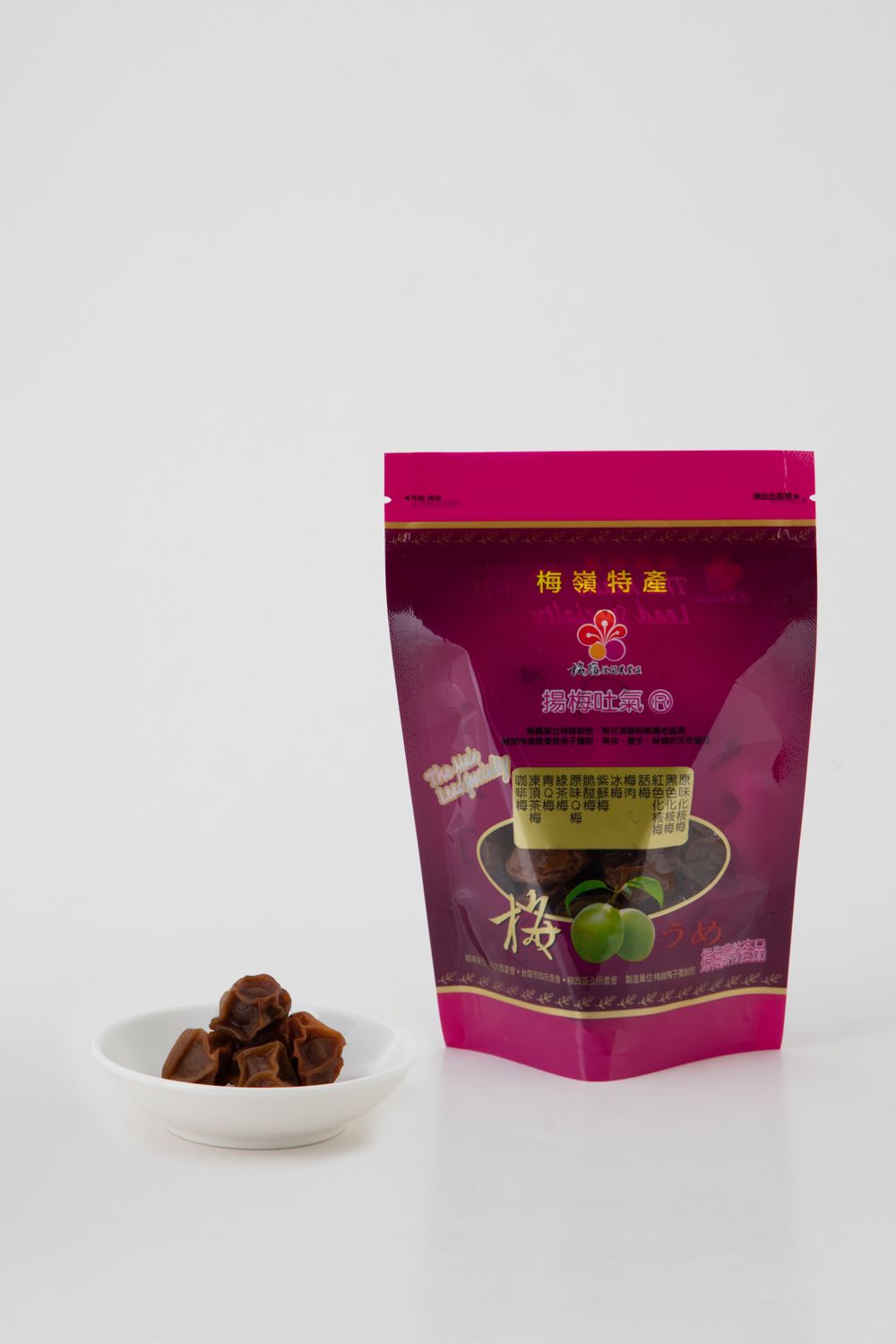白色背景上的一袋乾梅子和一小碟乾梅子。