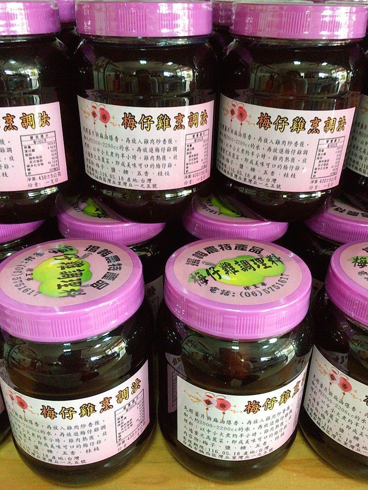 架子上堆放著幾罐深色黏稠的液體,罐子上貼著粉紅色和白色的標籤,蓋子也是粉紅色的。