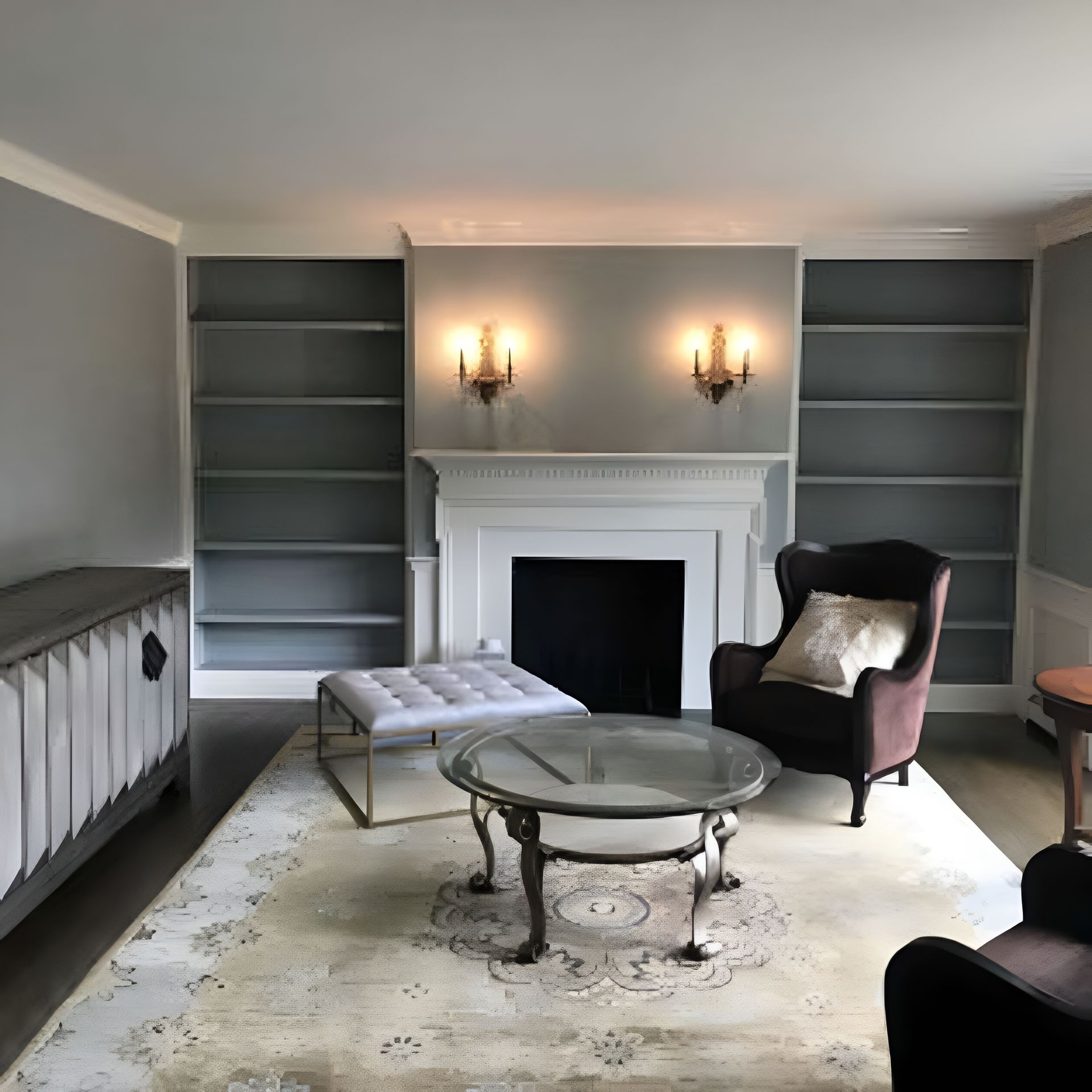 Living room with built-in bookshelves, fireplace, seating, and a rug. Gray walls and furnishings.