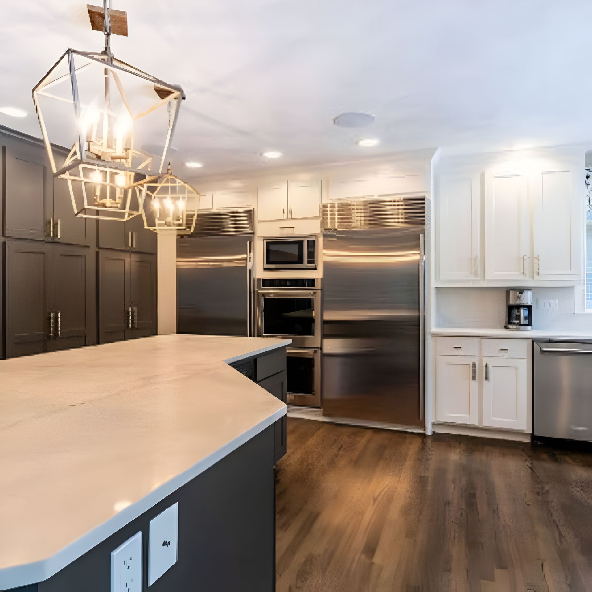 Modern kitchen with gray and white cabinets, stainless steel appliances, and a central island.