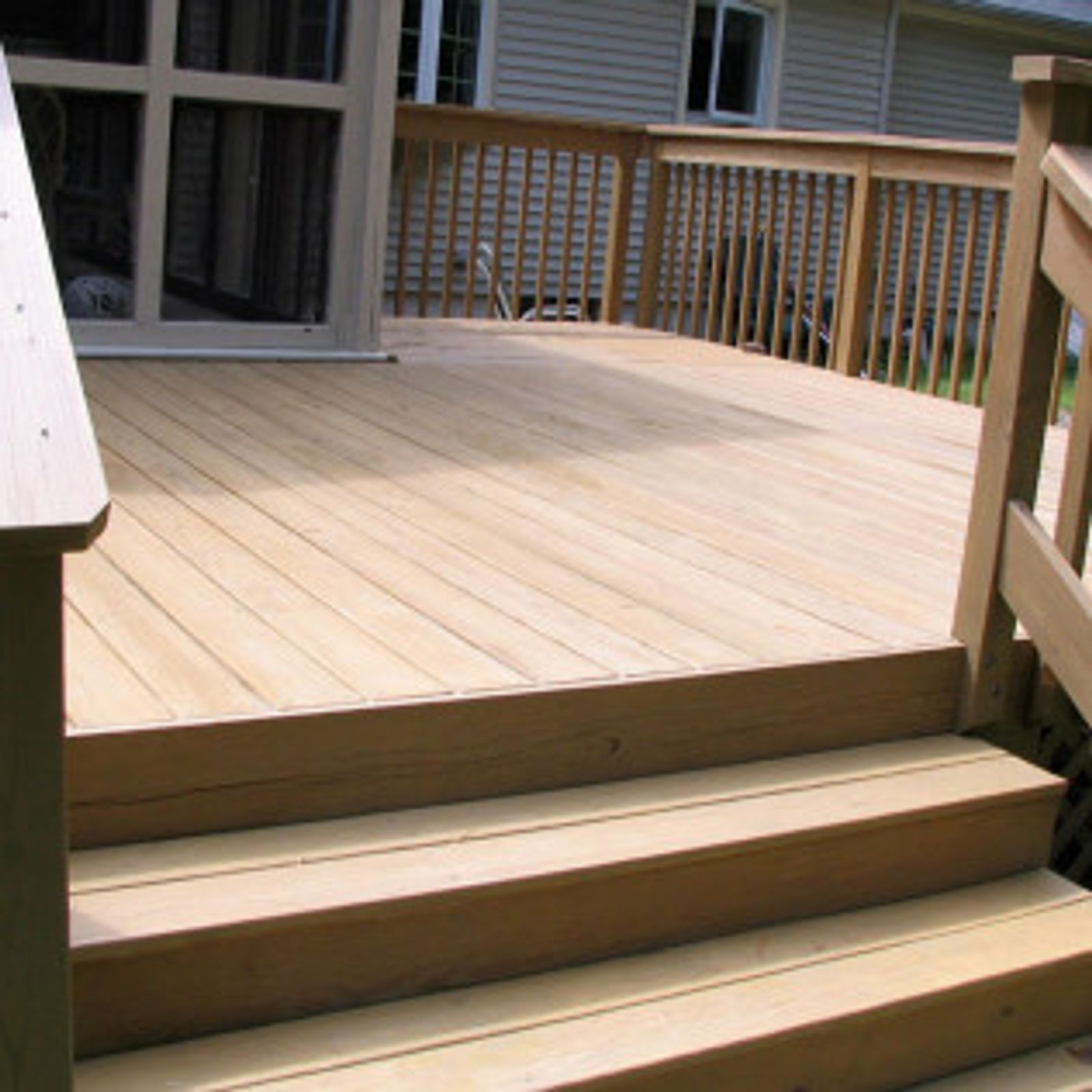 Wooden deck with steps leading down to the yard and a door to the house.