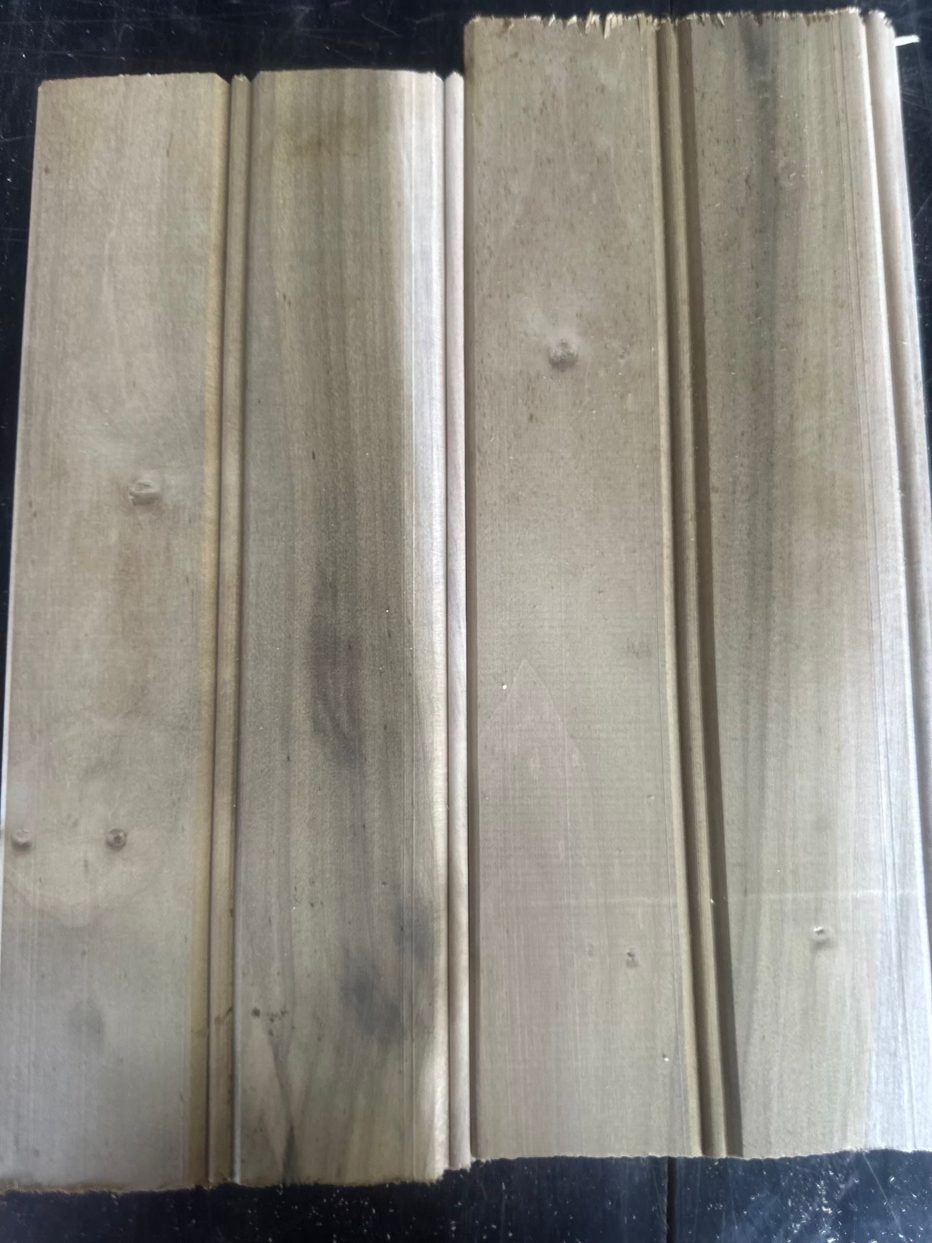Two weathered wooden boards with vertical grooves.