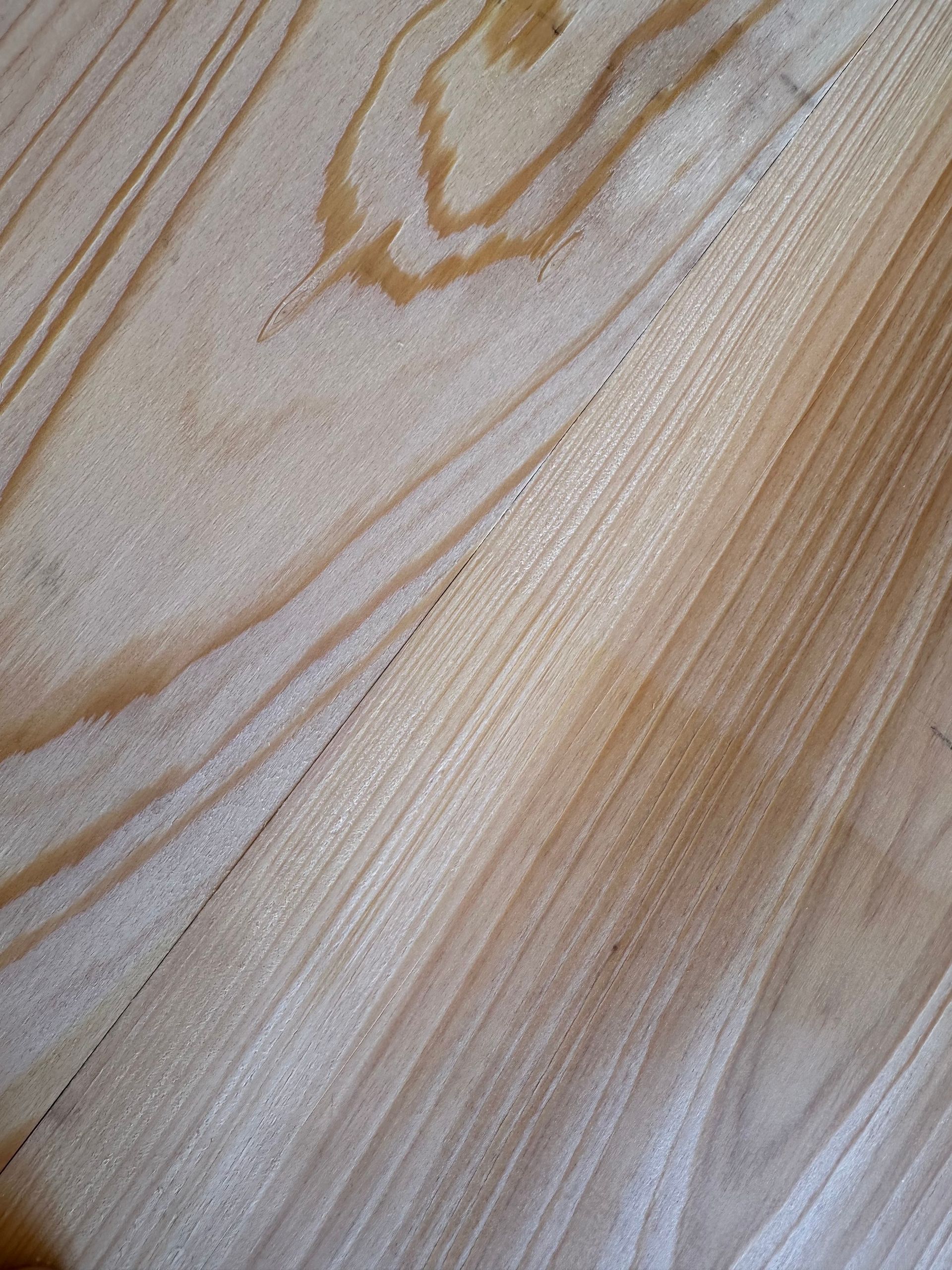 Light wood grain pattern with visible knots and straight lines.