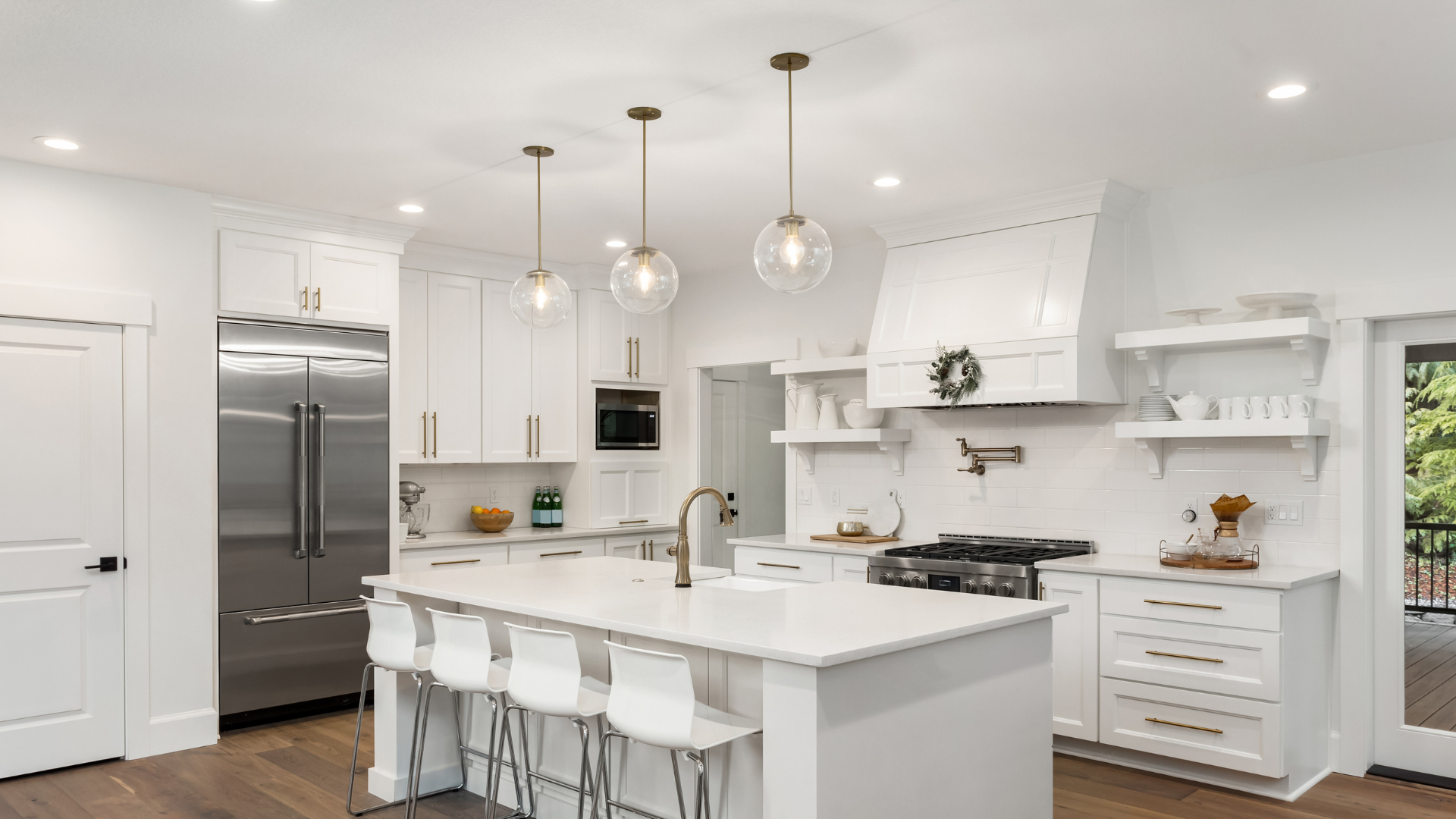 A kitchen with white cabinets , stainless steel appliances , and a large island.