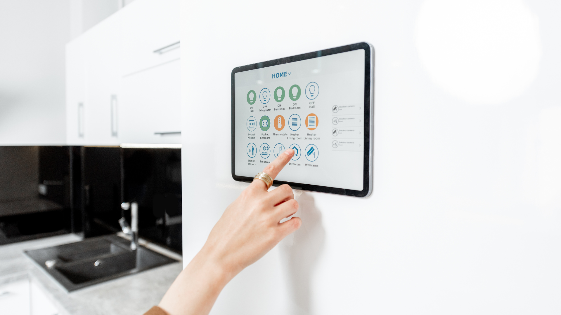 A person is pressing a button on a tablet in a kitchen.