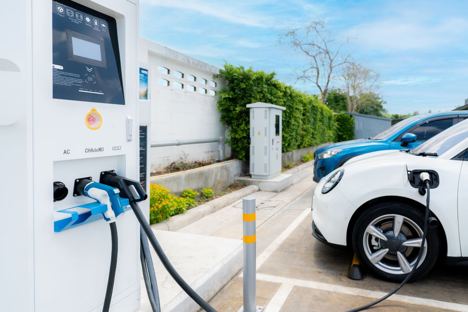 A white electric car is being charged at a charging station.