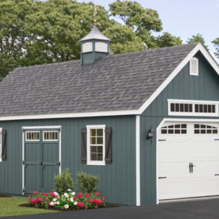 Teal detached garage with white trim, white door, and flower bed in front