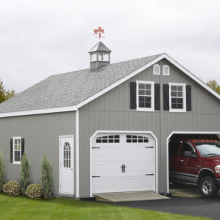 Gray garage with white doors and red truck parked inside under a small cupola