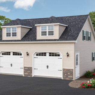 Two-story beige house with dark roof, two white garage doors, and small flower bed at the driveway.