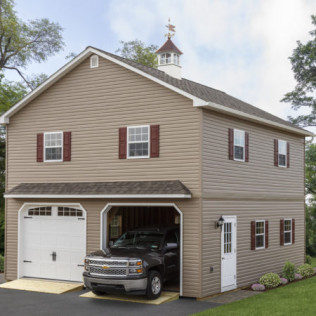 Two-story beige house with attached garage and parked black truck under an overcast sky