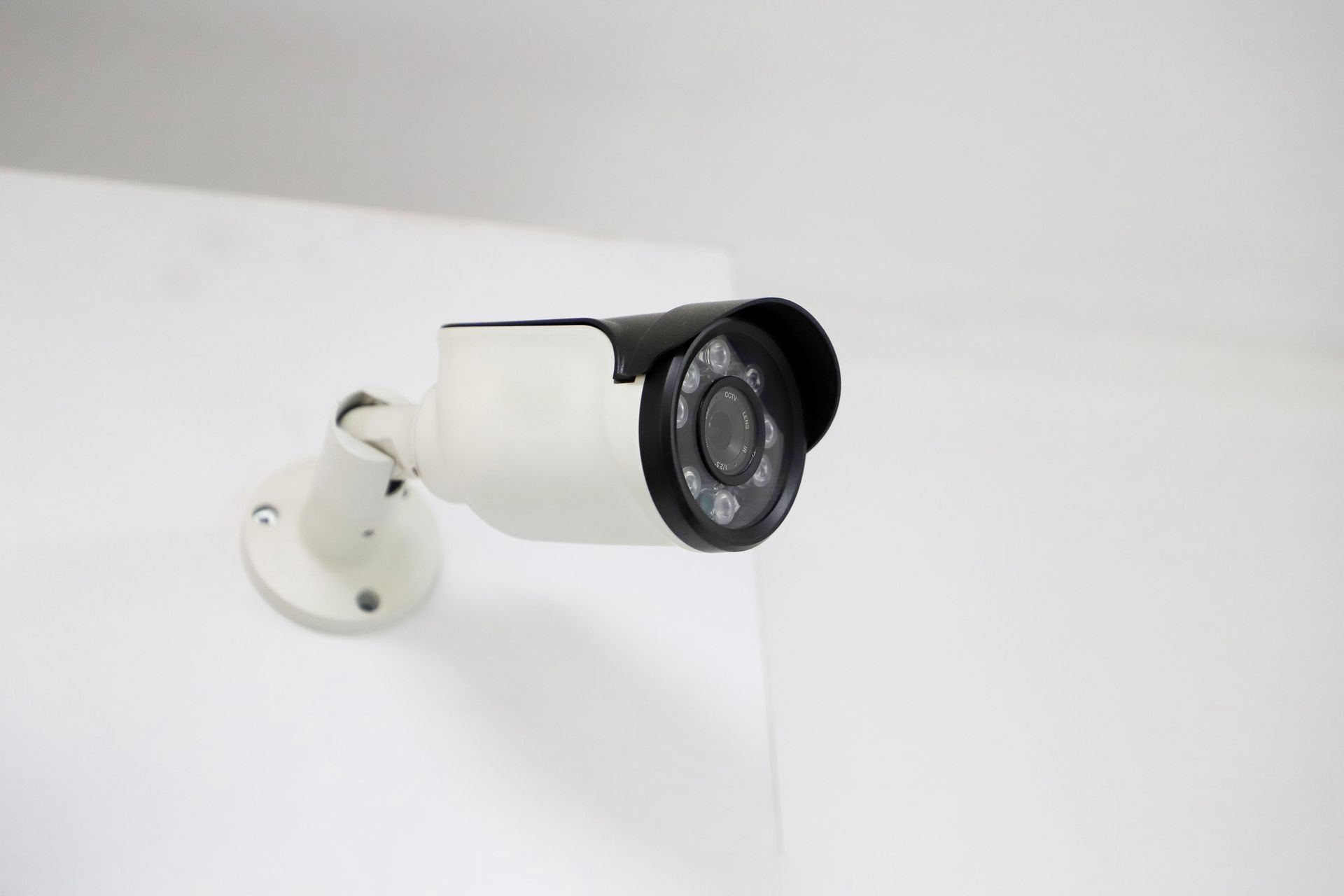 White wall-mounted security camera with infrared night vision LEDs.]