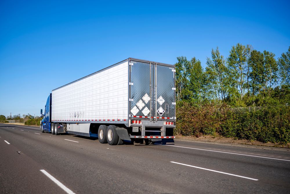 Semi-Truck Driving on Highway; Blue Cab, White Trailer, Blue Sky — Haigh Truck & 4WD Repairs In Orange, NSW