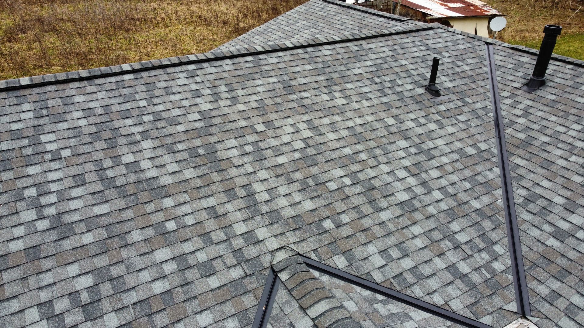 A roof with a lot of shingles and a chimney on it.