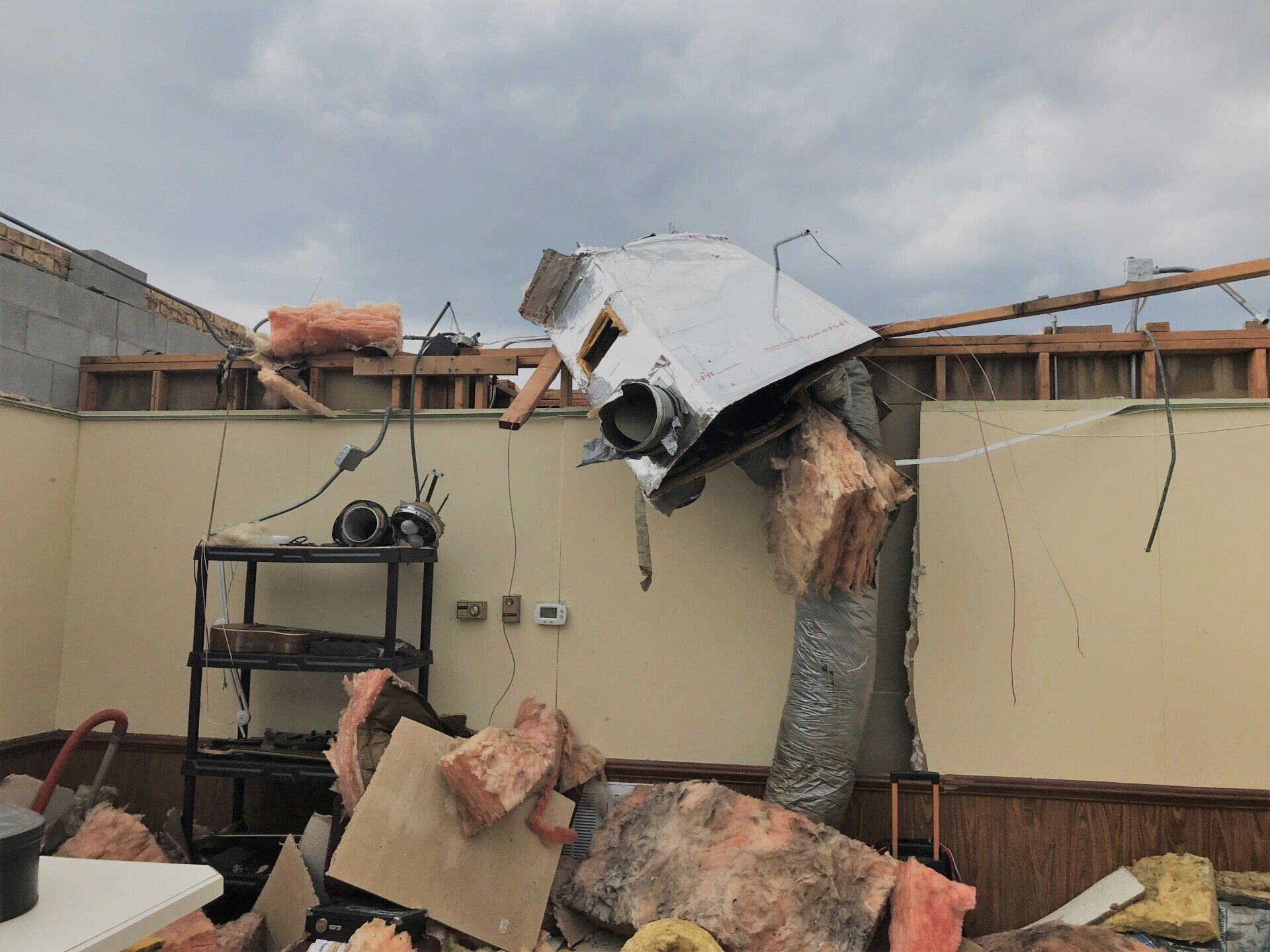 A tornado damaged building with the roof torn off by high winds.