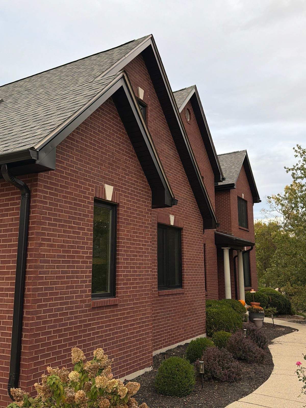 Finished black fascia and soffit on the gables of a two-story red brick home